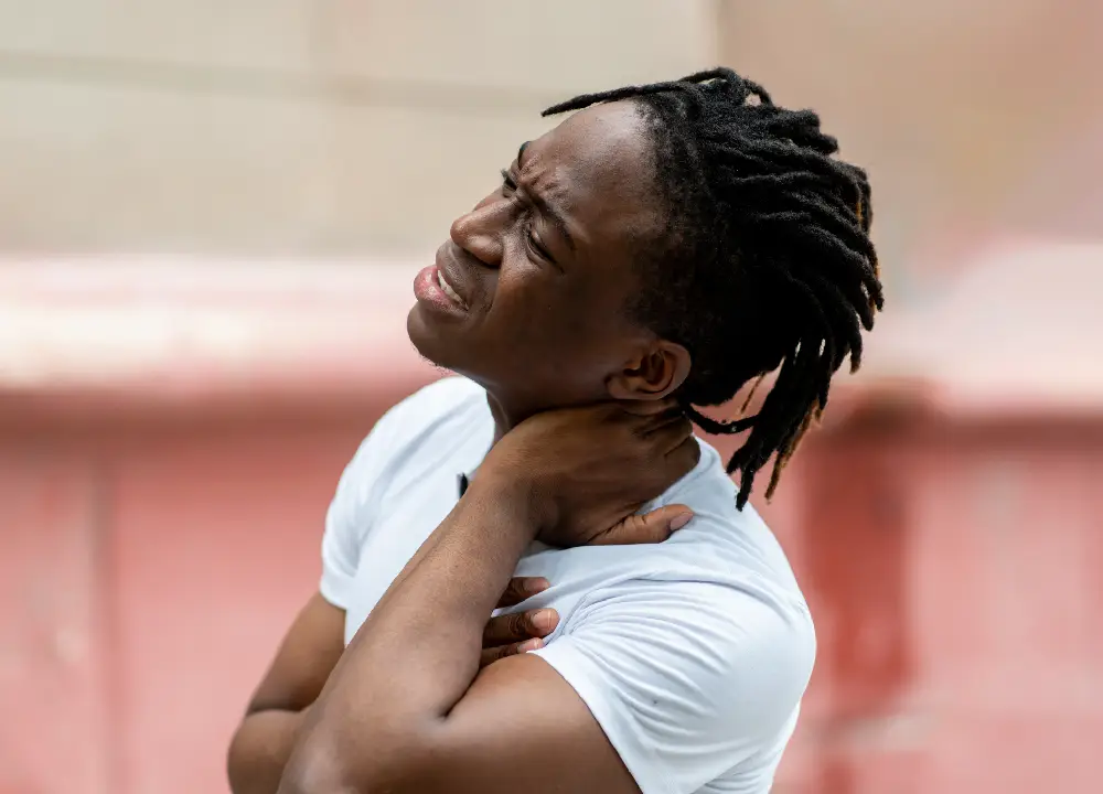 A man holding his neck in pain, showing symptoms of whiplash after an accident.